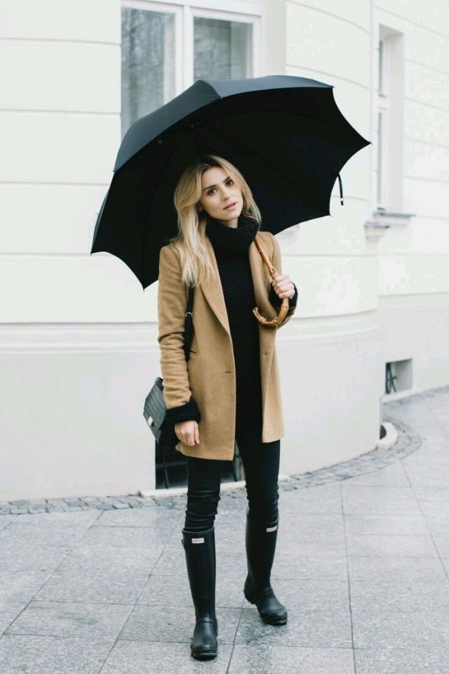 Woman wearing dark-coloured clothes and rain boots