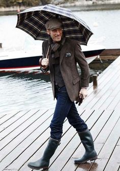 Man wearing dark-coloured clothes and rain boots